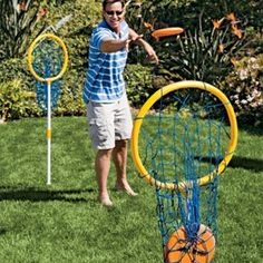 a man throwing a frisbee into a blue and yellow net on the grass