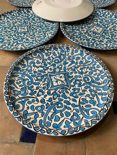 blue and white plates sitting on top of a tiled floor