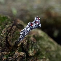 Made from sterling silver, this ring features intricate leaf and twig details, giving it a natural and rustic appeal. The captivating garnet at its center adds a touch of elegance and mystery. Characteristics: Metal - Recycled solid sterling silver  Stone - Cubic Zirconia Finish - Oxidized. View all silver celtic engagement rings: https://www.etsy.com/shop/TinyShinyJewel?ref=seller-platform-mcnav&section_id=44336419 Care instructions: To care for the ring, avoid contact with water and chemicals Silver Fantasy Promise Ring, Silver Fantasy Rings For Anniversary, Fantasy Silver Rings For Anniversary, Fantasy Style Silver Ring For Anniversary, Silver Magical Crystal Promise Ring, Magical Silver Crystal Promise Ring, Silver Magical Promise Jewelry, Magical Silver Crystal Ring For Anniversary, Silver Nature-inspired Crystal Wedding Ring