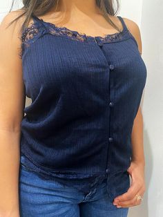 Navy Blue Lace Camisole Top The perfect balance of sophisticated and sexy. This pretty camisole is made with a deep navy blue fabric that has a detailed striped texture, which gives this top a slight shimmer. The v-shaped neckline is decorated with floral lace trim, which also lines the bottom hem of the top. Adjustable spaghetti straps. Fabric-covered buttons close down at the front. Model is wearing a size medium. Blue Camisole Top With Lace Trim, Flirty Fitted V-neck Camisole, Cheap V-neck Flirty Camisole, Fitted V-neck Flirty Camisole, V-neck Camisole With Lace Trim, Lace Camisole Top, Navy Blue Fabric, Lace Camisole, Fabric Covered Button