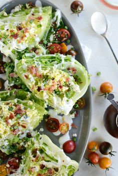 lettuce wrapped in bacon and tomatoes on a plate next to some dressings