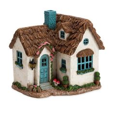 a white house with a blue door and windows on the front porch is made out of clay