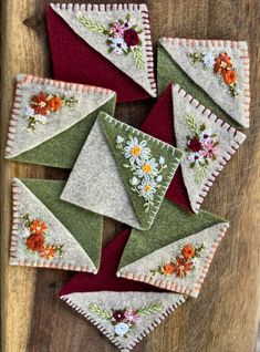 several pieces of fabric with flowers on them sitting on top of a wooden table next to each other