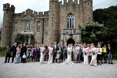 a large group of people standing in front of a castle