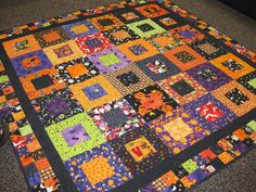 a colorful quilt is laying on the floor