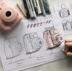 a person holding a camera next to some drawings