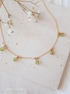 Discover the delicate "FREYA" necklace, inspired by the beauty of nature and crafted with elegance in mind. This exquisite piece features 18K gold plating and natural peridot gemstones, making it a timeless addition to any jewelry collection. ♡ Features ♡ - Adjustable size - 18K gold plated with 5 microns - Elegant Packaging: Ready to give or to keep - Timeless: Perfect for all occasions, and ideal for layering with other necklaces - Limited Quantity This nature-inspired necklace captures the es Delicate Necklace With May Birthstone, Delicate Green Birthstone Jewelry, Delicate Green Necklace With May Birthstone, Gold Briolette Necklace For May Birthstone, Yellow Gold Briolette Necklace For May Birthstone, Briolette May Birthstone Necklace, Delicate Green May Birthstone Necklace, Nature-inspired Gold Necklace With Gemstone, Green Briolette Necklace In Fine Jewelry Style