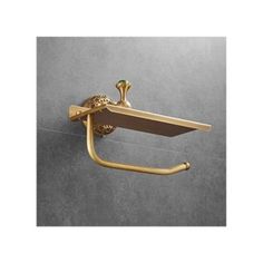 an antique brass towel rack with two towels hanging from it's sides and a hook on the wall