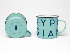 a teal mug with a black rim and the words hyptian on it