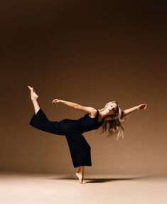 a woman in black dress doing a dance pose