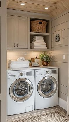 a washer and dryer in a laundry room with cabinets on the wall above them