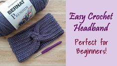 the crochet headband is next to a ball of yarn and knitting needles