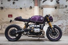 a purple motorcycle parked in front of a wall