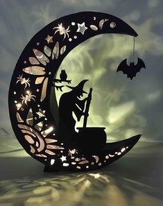 a paper cut out of the moon with a witch sitting on it and holding a broom