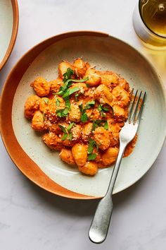 a white plate topped with shrimp next to a glass of beer and a silver fork