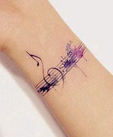 a woman's arm with a musical note tattoo on it