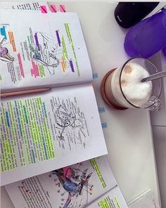 an open book next to a cup of coffee on top of a white countertop