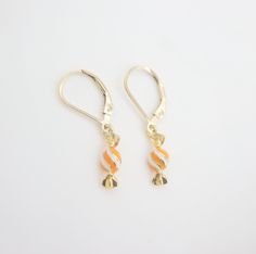 🎉Tiny enamel candy dangle earrings. 🎉Design and handcraft in our Burlington Studio ------------------------------------------------------------- PRODUCTS DETAILS Length: 29mm Width: 5mm Lever back: 14K gold filled Candy drop: 14K gold plated enamel ------------------------------------------------------------- SAME COLLECTION Necklace https://www.etsy.com/ca/listing/771460195/tiny-enamel-candy-necklace-14k-gold?click_key=b044d590c58e79aa95964c877bc70f9e68f174fc%3A771460195&click_sum=5f3b091c&ref=shop_home_active_28&sts=1 ------------------------------------------------------------- MATERIALS INTRODUCTION:  GOLD FILLED FINDINGS Gold filled is an actual layer of 5% pure gold by weight pressure bonded to another metal. Gold filled is not to be confused with gold plating as filled literally h White Enamel Jewelry For Party, Cadmium-free 14k Gold Earrings As Gift, Sweet Gold Dangle Jewelry, Yellow Gold Enamel Earrings As Gift, Personalized White Jewelry For Celebration, Sweet Gold Earrings For Gift, Gold Dangle Earrings For Birthday, Sweet White Earrings For Birthday, Nickel-free White Jewelry For Birthday