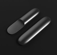 two black oval objects on a dark surface