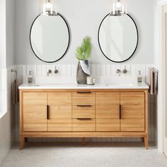 two round mirrors are above the double sink vanity