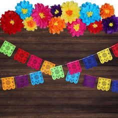 colorful paper flowers are hanging from a string on a wooden background with the word happy written below it