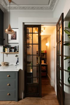 an open door leading into a kitchen with lots of counter space and decor on the walls