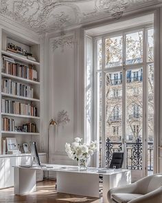 a living room filled with lots of furniture and bookshelves next to a window