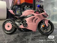 a pink motorcycle parked in front of a building