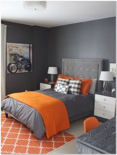 a bedroom with gray walls and orange accents