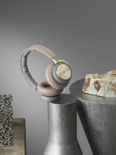 two headphones sitting on top of some metal cylinders next to a piece of bread