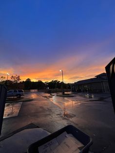 an empty parking lot at dusk with the sun setting