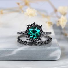 a ring with an emerald colored stone in the center