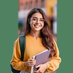 a girl with glasses holding a folder and smiling at the camera while standing in front of a green wall