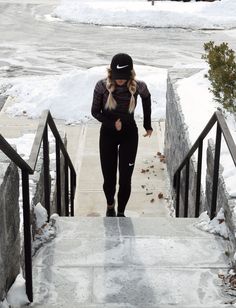 a woman walking up some stairs in the snow