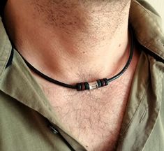 A stylish choker necklace for men is a stainless steel bead and black brown wooden beads on a genuine black leather cord with stainless steel lobster clasp closure.  This concise choker for every day will be a great gift for him. Stainless steel bead: 10 x 8 mm wooden beads: 8 x 2 mm Leather cord thickness: 3 mm For all products are used only genuine high-quality Italian leather, natural stones and wood. All metal materials are lead and nickel free.  /Gift wrapping and packaging/ :   All items ordered will be placed in a gift bag and shipped in a bubble mailer. /Jewelry care instructions/: Not recommended bathing, physical activity, swimming, sleeping while wearing jewelry. It may damage all the components of the product. Men Choker, Surfer Jewelry, Mens Leather Necklace, Cord Choker, Beads Choker, Necklace Everyday, Wooden Bead Necklaces, Leather Corded Necklace, Steel Wood