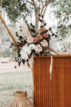 a vase filled with flowers sitting on top of a wooden table next to a basket