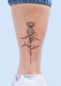 a woman's lower leg with a flower tattoo on her left side ribcage