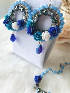 This Collection consist in Earrings and matching Bracelet , in rosary style , made using crystals in shades of blue and very small romantic roses .I love roses , I'm real passionate about these flowers !I have a lot of roses in my garden , some of them are ancient varieties and have an intense aroma and wonderful colors .For this particular collection I was inspired by my roses and I dedicate it to all women who love this flower like me .This  Collection is the result of a slow and detailed proc Turquoise Flower-shaped Jewelry For Wedding, Turquoise Flower Jewelry For Wedding, Turquoise Flower-shaped Wedding Jewelry, Blue Dangle Jewelry For Celebration, Turquoise Flower Jewelry For Party, Blue Dangle Flower Earrings For Wedding, Handmade Blue Jewelry Sets For Wedding, Handmade Blue Bridal Earrings For Wedding, Blue Flower-shaped Wedding Jewelry