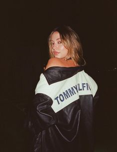 a woman wearing a black and white jacket with the word tommy on it's back