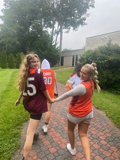 some girls are playing baseball on a brick path