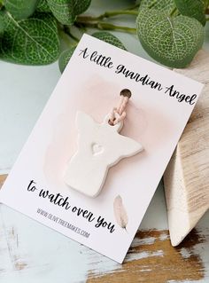 a little wooden angel charm on top of a card