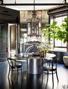 a dining room table with chairs and a chandelier hanging from it's ceiling