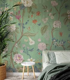 a bedroom scene with focus on the bed and wallpaper that's covered in flowers