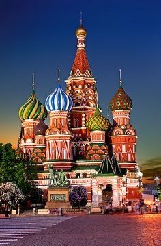 the building has many colorful domes on it's sides and is lit up at night