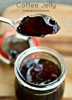 a spoon full of jam sitting on top of a wooden table