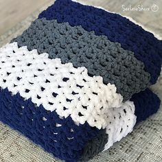 two crocheted blankets folded on top of each other, one blue and the other white