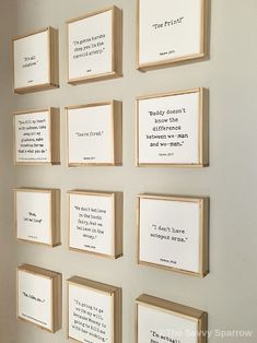 there are many framed pictures on the wall with words written on them and in different frames