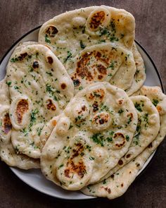 several flat breads on a plate with parsley