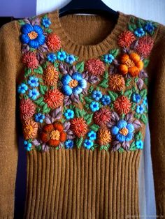 a brown sweater with colorful flowers on it