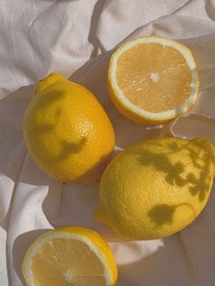 three lemons cut in half on a white cloth